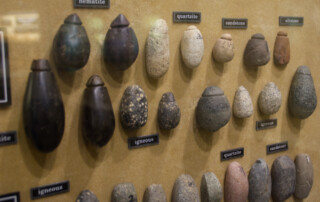 Stone tools including ax heads hanging on a wall
